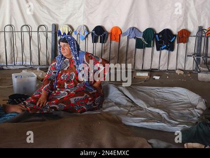 In this Wednesday July 9, 2014 photo, an Iraqi refugee woman from Mosul sits at a temporary camp for refugees who fled from Mosul and other towns outside Irbil, northern Iraq, nearly a month after Islamic militants took over the country's second largest city. The lightning sweep by the insurgents over much of northern and western Iraq the past month has dramatically hiked tensions between the country's Shiite majority and Sunni minority. At the same time, splits have grown between the Shiite-led government in Baghdad and the Kurdish autonomy region in the north. (AP Photo)