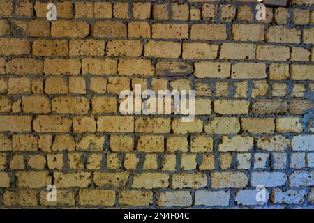 Old yellow wall of limestone with grey seams. Stock Photo
