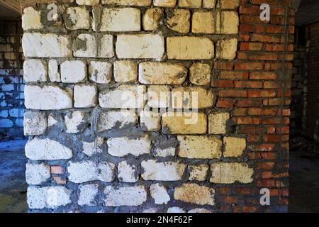 Old white red wall of different bricks with grey cement seams, closeup Stock Photo