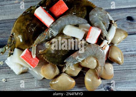 background of fresh seafood marine crabs, shrimps, clams, mussels, gandofli, oysters, crab sticks, calamari, squid and fish fillet ready to be cooked Stock Photo