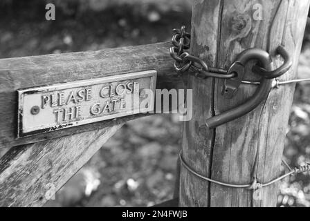 PLEASE CLOSE THE GATE sign next to a gate hook shape/pattern that is typically seen in the Lake District and parts of North Yorkshire. Stock Photo