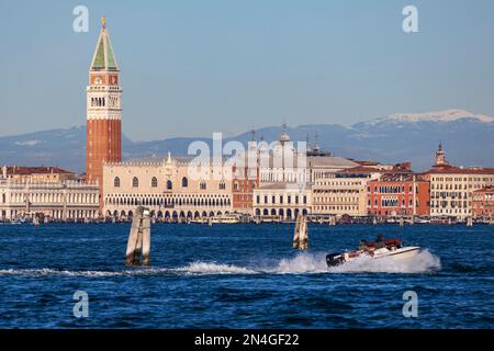 Motor boat in front of St. Mark's campanile, Doge's Palace, and the Dolomites, Venice, Veneto, Italy, Europe Stock Photo