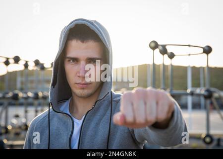 Portrait of confident young man wearing cap and showing his fist. Stock Photo