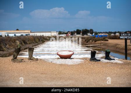 Two pair of boots and bowl full of salt at Salt marshes, Isla Cristina, Spain Stock Photo