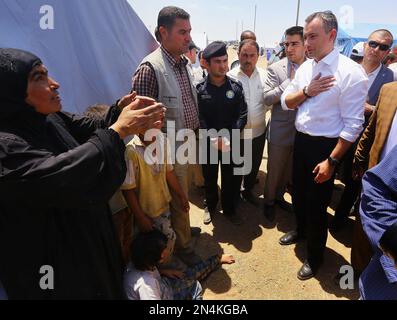 Nickolay Mladenov, second from right, the U.N. envoy to Iraq, speaks with an Iraqi woman who fled Mosul at the Khazir refugee camp outside Irbil, 217 miles (350 kilometers) north of Baghdad, Iraq, Saturday, June 14, 2014. Mladenov said a 'political solution' is the only answer to the ongoing conflict in Iraq, during a trip to the country to monitor the humanitarian crisis. His comments on Saturday came as fighters from the al-Qaida splinter group, drawing support from former Saddam Hussein-era figures and other disaffected Sunnis, have made dramatic gains in the Sunni heartland north of Baghda