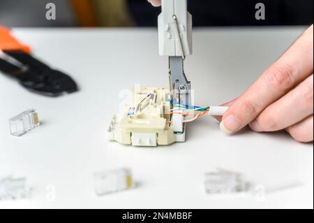installing a network cable into a prefabricated RJ45 module using the LSA punch down tool, ethernet socket Stock Photo