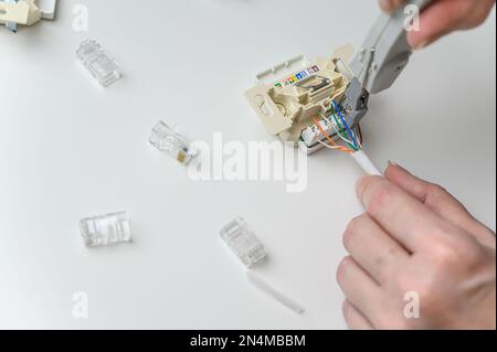 installing a wall ethernet socket. Connecting wires to an socket. Stock Photo