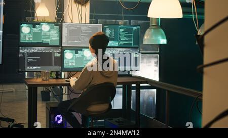 Team of people hacking system with computer malware, working on cyberbullying late at night. Hackers phishing for information, stealing valuable information, breaking firewall encryption. Stock Photo