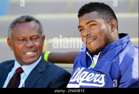 Former Los Angeles Dodger Manny Mota, left, gets a hug from his son Jose as  he is inducted into the Legends of Dodger Baseball prior a baseball game  between the Dodgers and