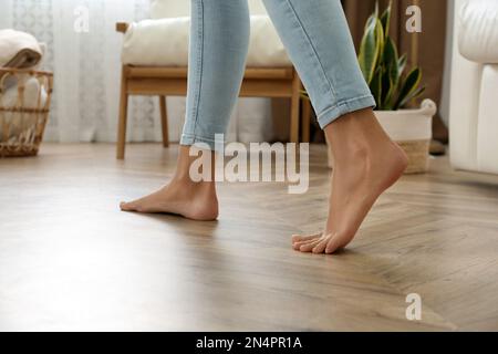Woman walking barefoot at home, closeup. Floor heating concept Stock Photo