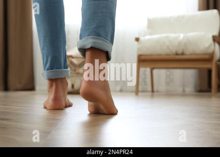 Man walking barefoot at home, space for text. Floor heating concept Stock Photo