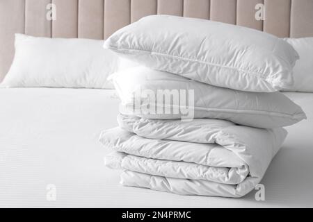 Soft folded blanket and pillows on bed indoors Stock Photo