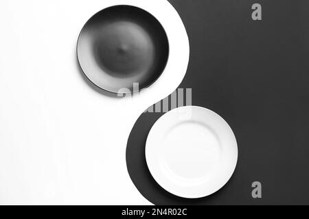 Yin Yang symbol made with plates on color background, flat lay. Zen concept Stock Photo