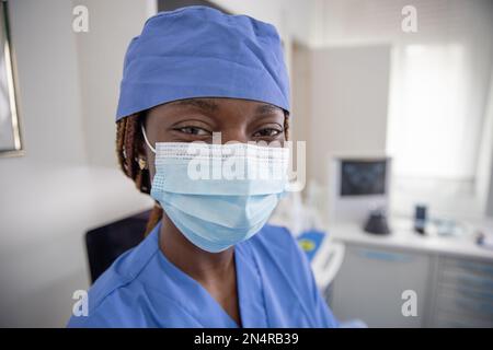Portrait of an African female doctor in her office wearing a surgical mask. Stock Photo