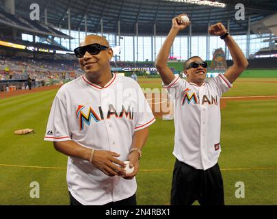 Former MLB pitchers Livan Hernandez, left, and his half-brother Orlando  El  Duque Hernandez, right, chat with Jacob Forever, former member of the  Cuban reggaeton group Gente de Zona, after throwing out
