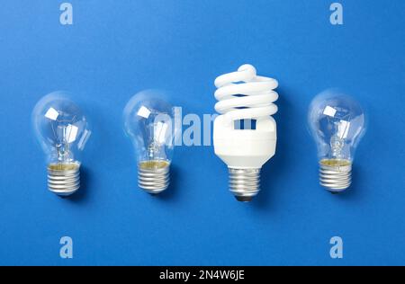 Vintage and modern lightbulbs on blue background, flat lay Stock Photo