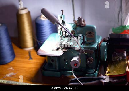 A Green Sewing Machine, With Some Lumps Of Thread On The Table Stock Photo