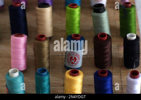 Bundles Of Thread Of Various Colors, Arranged On Wooden Wall Boards Stock Photo