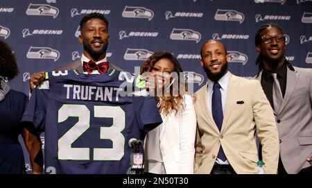 Seattle Seahawks Marcus Trufant left holds up a team jersey as he stands with his wife Jessica and brothers Isaiah second right and Desmond to start a news conference announcing his retirement from fo...