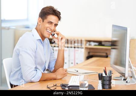 Im all over this project. Portrait of a smiling businessman sitting at his desk in front of his computer. Stock Photo