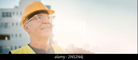 Senior man, builder and construction in the city with smile and helmet for safety or security at site on mockup. Elderly male contractor, engineer or Stock Photo