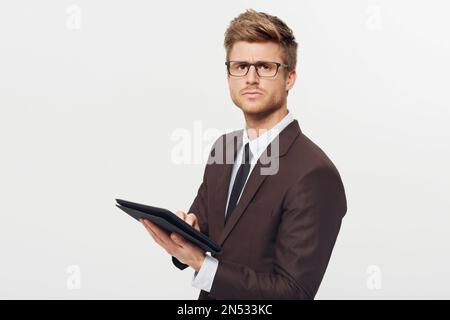 Im concerned about these numbers...Studio portrait of a stylishly-dressed young businessman holding a digital tablet. Stock Photo