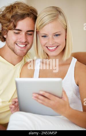 This is awesome. A young couple getting to grips with their new digital tablet. Stock Photo