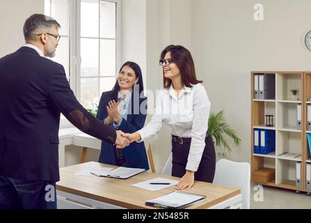 Happy HR managers shaking hands with a successful candidate after a job interview Stock Photo