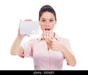 She cant believe this. Studio portrait of an surprised-looking young woman pointing at a small blank sign while isolated on white. Stock Photo