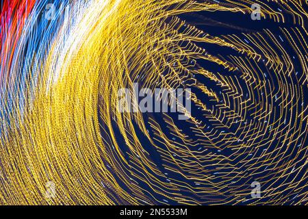 Abstraction blurred movement lights garlands. Golden lights of a blurred garland on the background of a purple blue sky. The concept of a night Stock Photo