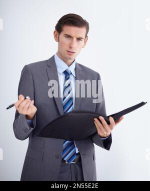 You can talk to me...A young businessman taking notes and looking at you skeptically. Stock Photo