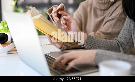 Close-up image of two Asian female marketing workers discussing, brainstorming and working together in the office. Stock Photo