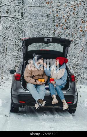 The couple stopped their car for lunch on the way through the forest Stock Photo