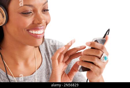 Enjoying the entertainment value of technology. A smiling ethnic woman with her headphones on playing with her iphone. Stock Photo