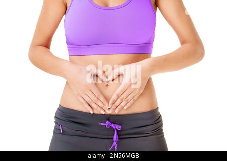 Love your body. a woman making a heart-shape on her stomach with her hands isolated on white. Stock Photo