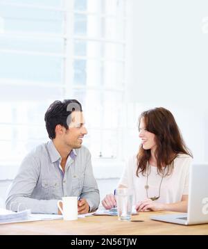 Im feeling confident about our project, and you. two colleagues having a friendly conversation while working together. Stock Photo