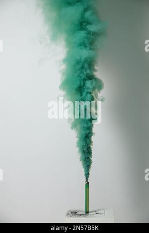 Bright green smoke bomb on white background Stock Photo