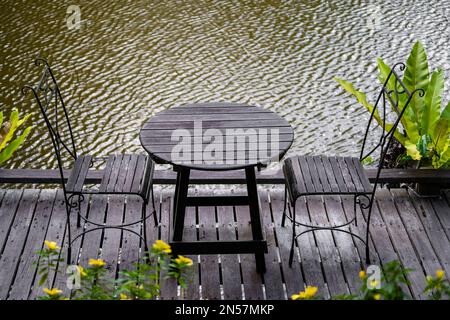 Two chairs and table on the backyard in tropical garden near lake with beautiful view in island Borneo, Malaysia, close up Stock Photo