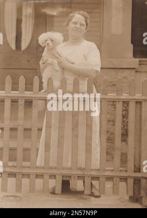 Vintage Photograph of Lady and her pet dog / hand holding puppy / hugging dogs / Dog Hugs / Holding dog under arm Stock Photo