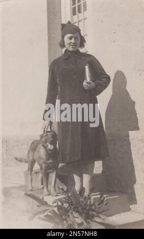 Vintage Photograph of Lady and her pet dog / hand holding puppy / young lady posing with her super happy puppy / happy dog for the camera at 1930s Stock Photo