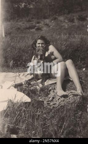 Vintage Photograph of Lady and her pet dog / hand holding puppy / hugging dogs , Dog Hugs / big dog / protector / safe dog / sun bathing with dog / Holding dog under arm Stock Photo