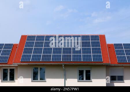 photovoltaic PV sun collector solar panels on sloped clay house roof. blue sky and white clouds. alternative energy. environment protection. off grid Stock Photo