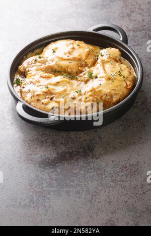 Creamy smothered pork chops seared and cooked in a rich onion gravy closeup on the pan on the table. Vertical Stock Photo