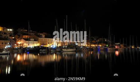 Yachts moored in Mali Losinj .Docked yachts in the harbour of Mali Lošinj city, Croatia.Yacht port at night. Stock Photo