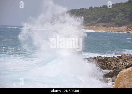 Wave splash in the ocean against beach reef, Wave splash. Powerful Waves on a rocky beach.Waves crushing into the rocks, Island Losinj, Croatia Stock Photo