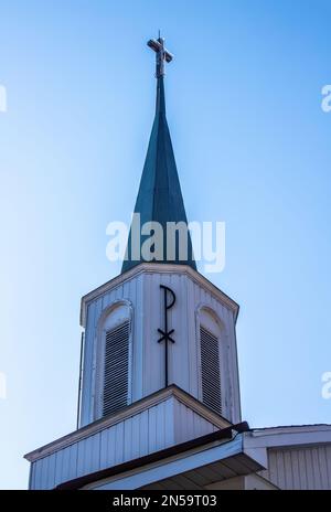 St. Joseph's Catholic Church steeple with a Pax Christi symbol on it and a cross at the top on a spring day in Taylors Falls, Minnesota USA. Stock Photo