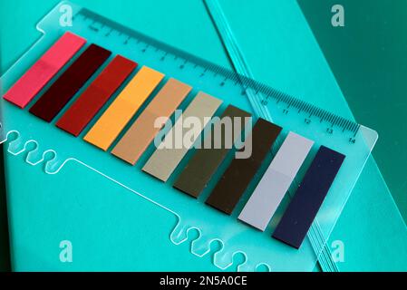 set of colorful sticky notes or paper tags and ruler on mint green notebook - selective focus Stock Photo