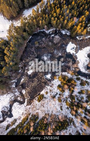 Aerial view of a frozen river with ice floes and snow-covered banks in ...