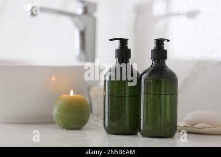 Green soap dispensers on countertop near sink in bathroom. Space for text Stock Photo