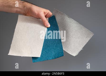 Choosing the fabric which fits to a grey wall. Stock Photo